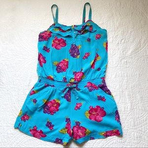 Blue Hawaiian romper with pink and purple hibiscus flowers